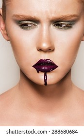 Portrait Of Young Woman Wearing Vogue Style Makeup. Beautiful Full Lips With Too Much Lipgloss Applied. 