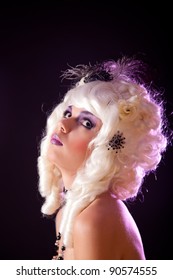 Portrait Of Young Woman In White Colonial Wig, Studio Shot On Purple Background