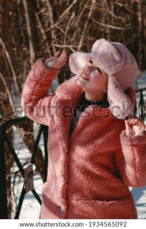 Portrait of a young woman in a winter fur hat outdoors. Winter Holidays Concept