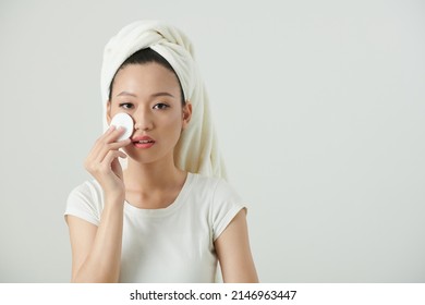 Portrait Of Young Woman Wiping Toner On Face With Cotton Pad To Restore Skins PH Level