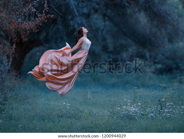 portrait young woman witch floating air spirit\
power spirituality ghost butterfly. luxury dress waving silk skirt\
fabric fly wind. Cold blue green grass forest. Enchanted princess\
Art photo levitation
