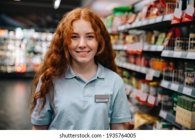 Portrait of a young woman working at supermarket during holidays. Woman doing a part time job grocery shop.