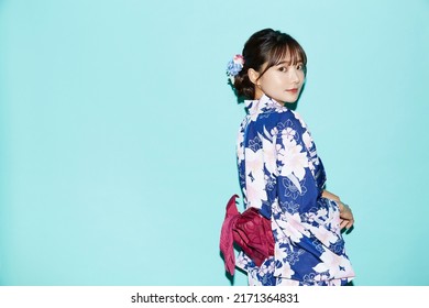 Portrait of young woman in yukata on blue background