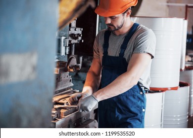 Portrait of a young worker in a hard hat at a large metalworking plant. The engineer serves the machines and manufactures parts for gas equipment. - Shutterstock ID 1199535520