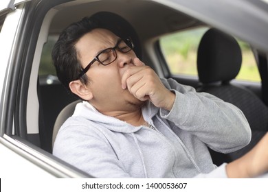 Portrait Of Yung Asian Male Driver Yawning Due To Sleepy Tired While Riding A Car, Danger Traffic Accident Insurance Concept