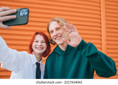 Portraits Of Two Smiling Caucasian Teen Friends Boy And Girl Posing For Selfie Using A Smartphone. Careless Young Teenhood 
 Time And Modern Technology Concept Image.