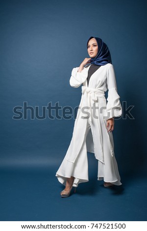 Portraiture of beautiful young Muslim Girl wearing hijab and Casual outfit.Studio shot with dark blue background.Office attire fashion.
