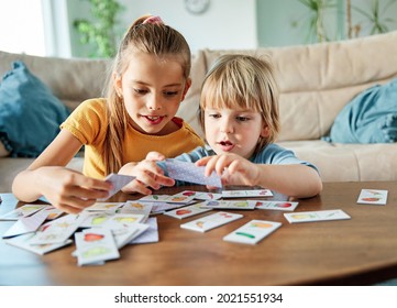 Portret of brother and sister having fun together playing board game at home
