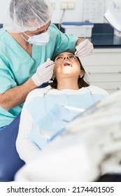 Portret of male dentist and woman patient sitting in medical chair during checkup at dental clinic office - Shutterstock ID 2174401505