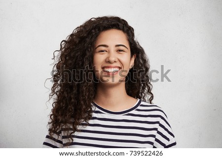 Similar – Image, Stock Photo Young woman in striped blouse smiling in urban setting