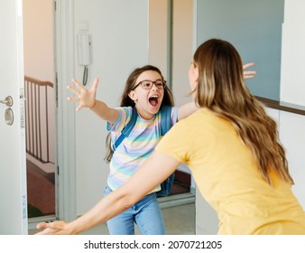 Portriat Of A Young Teen School Girl With Backpack Welcomed By Her Mother After Coming Back From School At Home