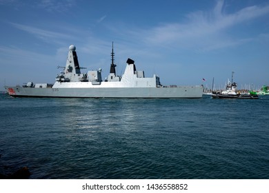 Portsmouth, Hampshire, UK June 28 2019 Daring Class Destroyer HMS Dragon Leaving Port Escorted By Tugboat SD Independent