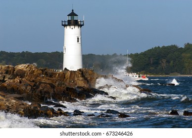 Portsmouth Harbor Lighthouse guides fishing boat amid crashing waves away from the dangerous rocky shore.
