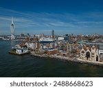 Portsmouth old town aerial seafront view with Spinnaker tower. Historic buildings at waterfront and modern architecture. Ferry ready to leave Portsmouth harbor. Blue sky with clouds.