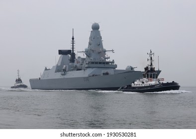 PORTSMOUTH, UK – 3RD MAR 2021: The Tugs BOUNTIFUL And INDULGENT Escort The Destroyer HMS DEFENDER Towards The Harbour Entrance. The Ship Is Returning Alongside After Post Maintenance Period Sea Trials