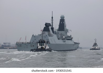 PORTSMOUTH, UK – 3RD MAR 2021: Tugs Escort The Destroyer HMS DEFENDER Towards A Berth In The Naval Base. The Ship Will Form Part Of The UK Carrier Strike Group Deployment In May This Year