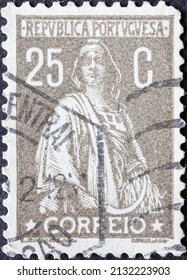 Portugal - circa 1930 : a postage stamp from Portugal, showing a woman from Portuguese mythology called Ceres with a sickle. Goddess of agriculture and fertility