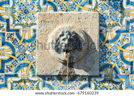 Portugal, fountain with azulejos and head of lion sculptured in the stone