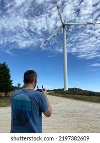 Carreço, Portugal, June 10, 2021: Man Piloting A Drone In The Air With A Remote Controller In His Hands. A Pilot Takes Aerial Photos And Videos With A Quadcopter From Above. 