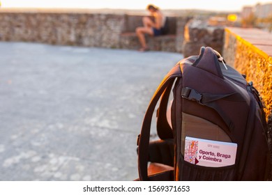 Portugal pocket guidebook at backpack. Young tourist woman on background - Shutterstock ID 1569371653