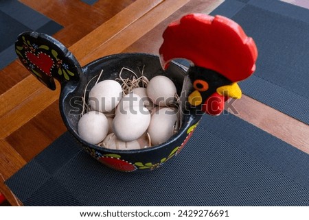 Portuguese ceramics, Barcelos cock, rooster, on a table With eggs. Galo de Barcelos