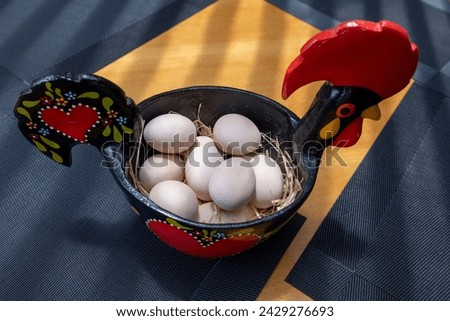 Portuguese ceramics, Barcelos cock, rooster, on a table With eggs. Galo de Barcelos