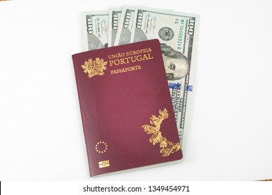 Portuguese passport (Translation "European Union Portugal passport") and one hundred dollar banknotes white background