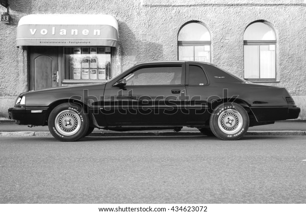 Porvoo, Finland - May 7, 2016: Ford Thunderbird\
ninth generation stands parked on the street. It is a personal\
luxury coupe built by Ford for the 1983 to 1986 model years. Side\
view, black and white