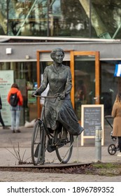 Posbank, The Netherlands - December 28, 2020: Bronze Statue Of Former Queen Beatrix With People Around The Pavilion Behind In The Dutch National Park Inside The Veluwe Region