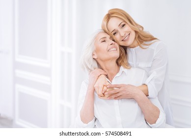 Posditive Woman And Her Adult Daughter Resting At Home