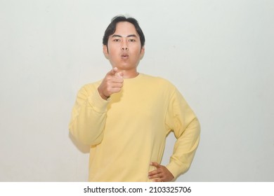 Pose Of An Asian Man Pointing At The Camera. Illustration Of A Teacher, Messenger, Motivator, Businessman, Student, And Public Speaking
