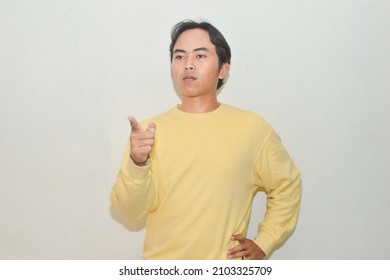 Pose Of An Asian Man Pointing At The Camera. Illustration Of A Teacher, Messenger, Motivator, Businessman, Student, And Public Speaking
