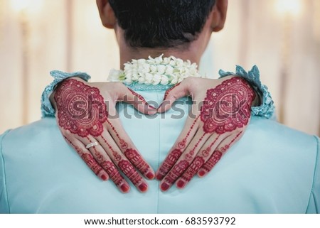 A pose of the brides hand with a nice henna over the shoulder of the groom