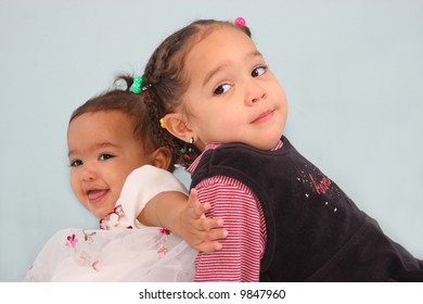Posed sisters back to back pushing each other away