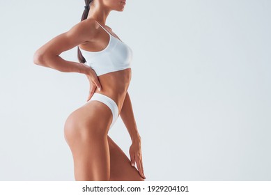 Posing for a camera. Beautiful woman with slim body in underwear is in the studio.
