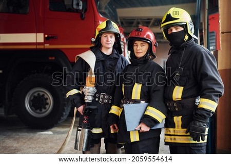 Posing for a camera. Group of firefighters in protective uniform that is on station.