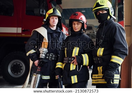 Posing for a camera. Group of firefighters in protective uniform that is on station.