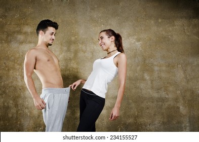 Posing couple in wall background joking about penis and other sexual issues