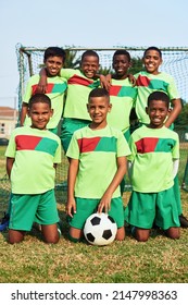 Posing Proudly For Their Team Photo. Portrait Of A Boys Soccer Team On A Sports Field.