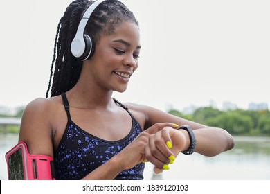 Positing young Black sportswoman pointing at fitness tracker on her wrist - Powered by Shutterstock