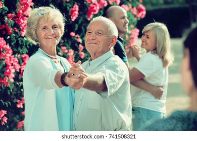 Positive  Adult Friends Dancing Pair Dance In Garden