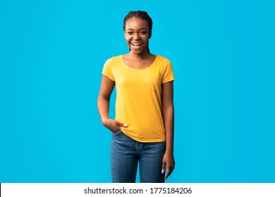 Positive African American Girl In Braces Smiling To Camera Posing Standing In Studio On Blue Background. Copy Space