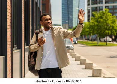 Positive African American Man Waving And Smiling While Walking Down The Street.