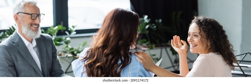 Positive African American Woman Talking To Lesbian Girlfriend Near Smiling Middle Aged Realtor, Banner