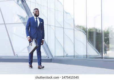 Positive Afro Businessman With Briefcase Walking In Urban Area. Copy Space - Powered by Shutterstock