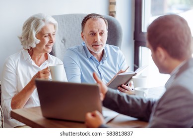 Positive aged couple consulting with insurance agent - Shutterstock ID 583813837