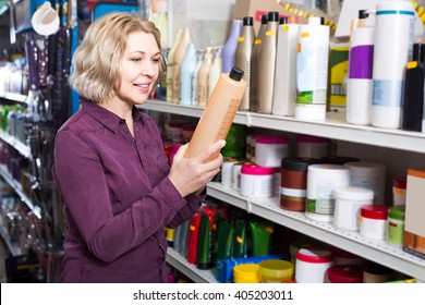 Positive American  Mature Female Customer Buying Volume Shampoo In Supermarket Hair Section 