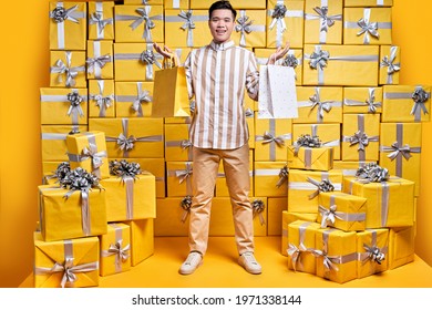 Positive Asian Gentleman Holding Some Shopping Bags, Going To Celebrate Birthday, Congratulate