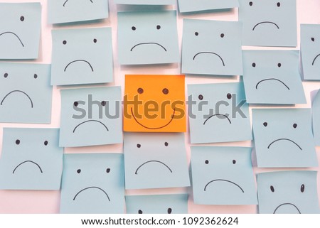 Positive Attitude and Happy Concept. Hand Drawn A Smile Face And Sad Emotion on Sticky Note Background. 商業照片 © 