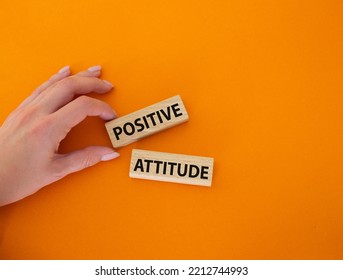 Positive Attitude Symbol. Concept Words Positive Attitude On Wooden Blocks. Beautiful Orange Background. Businessman Hand. Business And Positive Attitude Concept. Copy Space.